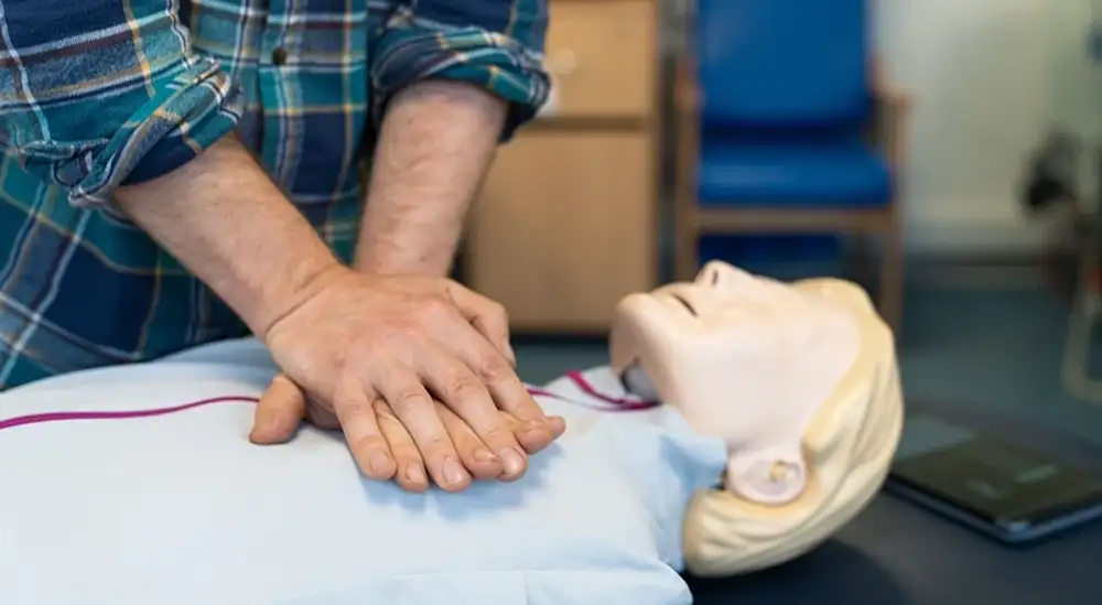 A student performing CPR on a dummy close up