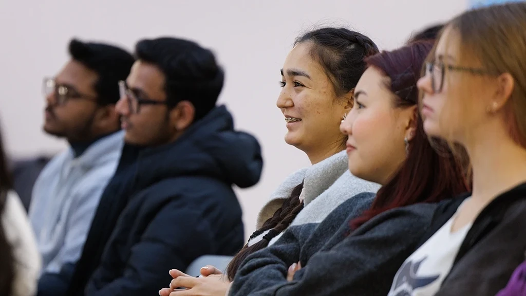 a group of students smiling while sitting down