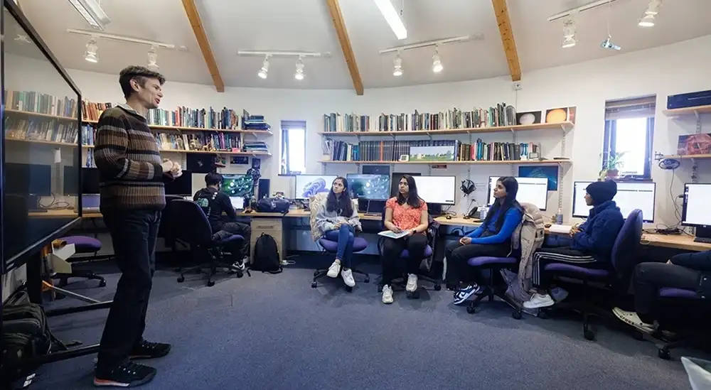 A group of students listening to lecturer in a circular room