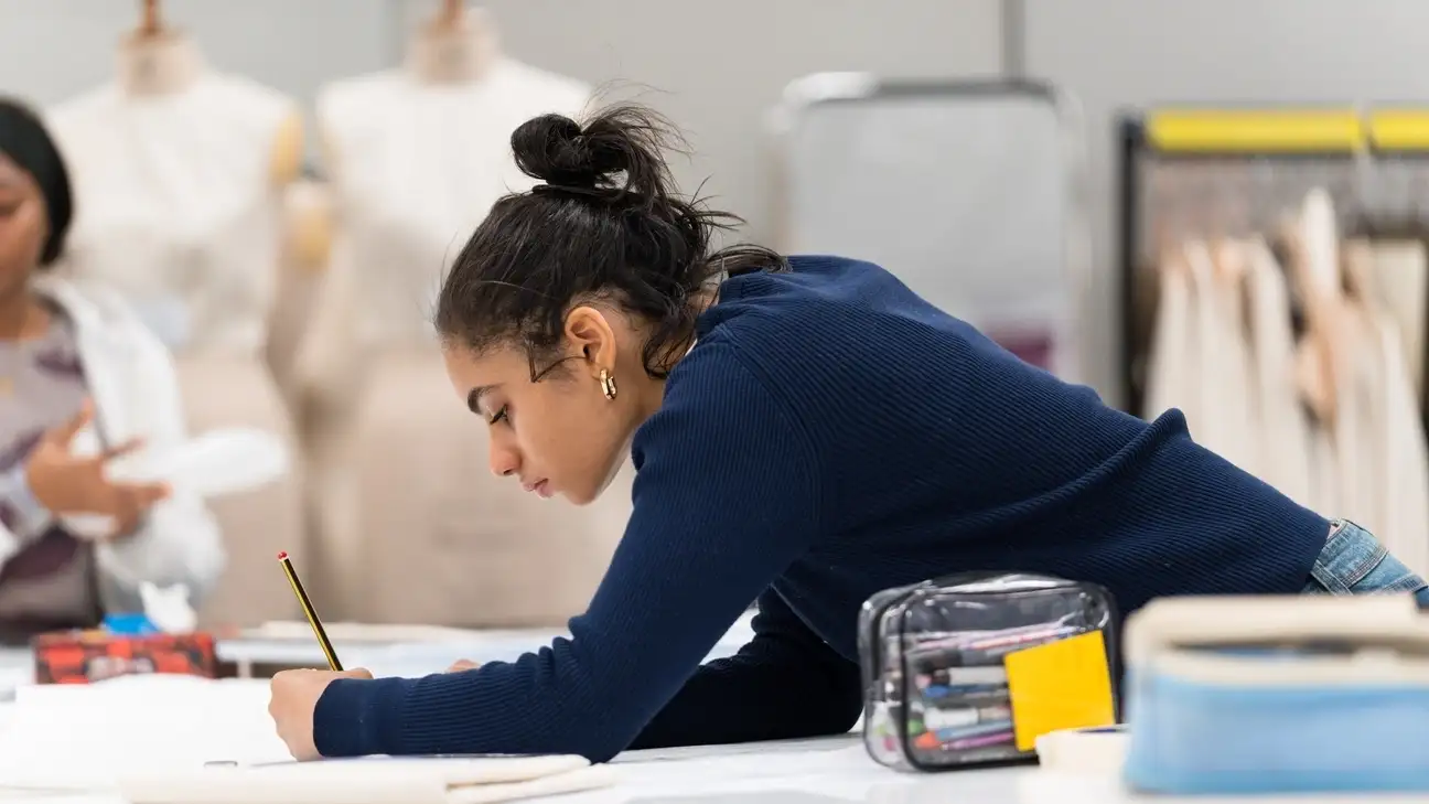 A student drawing on a sheet