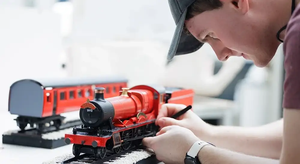 A student painting a model train