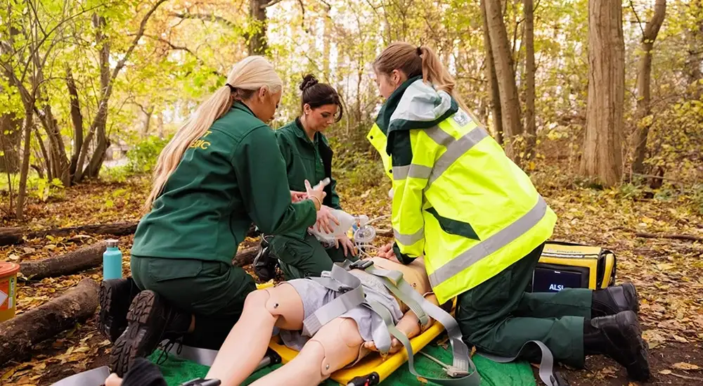 Students practicing CPR in woods