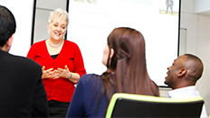 Academic teaching three students in classroom