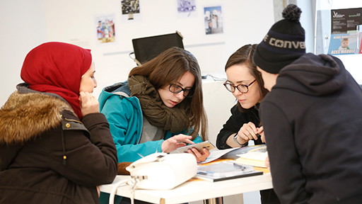 a group of students look at a mobile phone