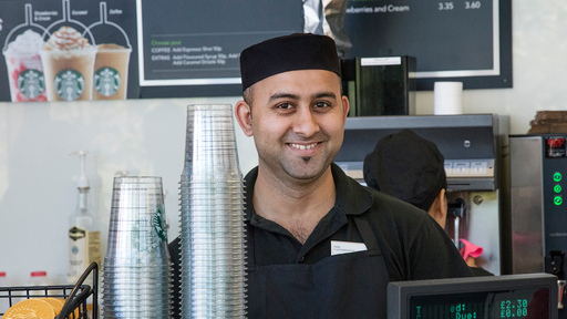 a member of staff in Starbucks smiles
