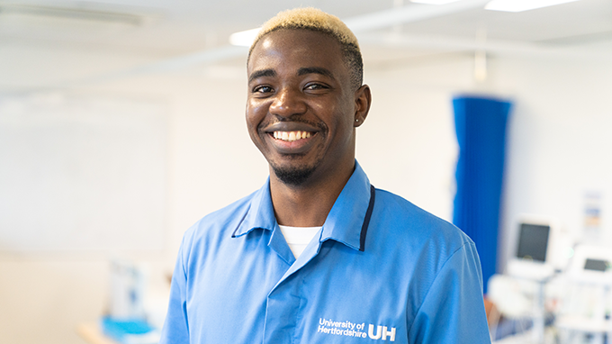 Male nursing student smiling at camera in University uniform