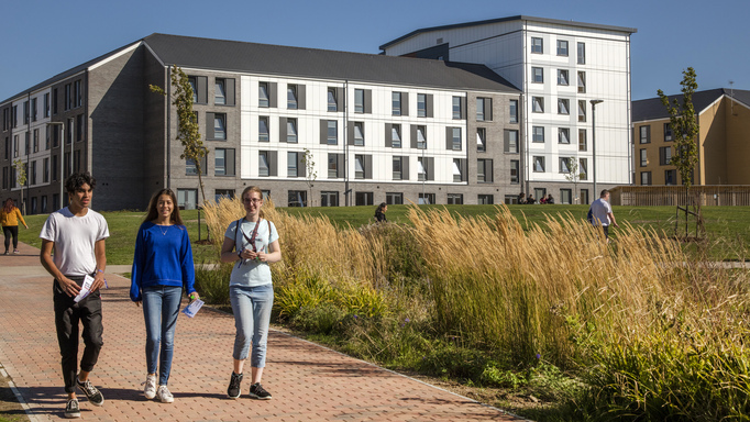 Image of a group of three students walking on university campus
