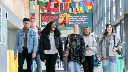 Five students walking down the Street of deHavilland Campus