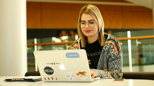 Female student with blonde hair working on laptop