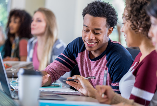 Male student smiling and studying 