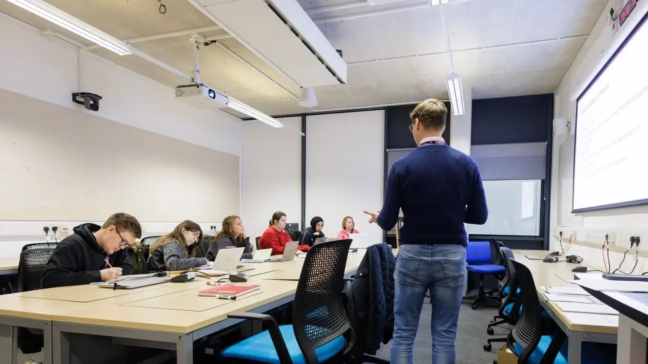Lecturer talking to students in a classroom