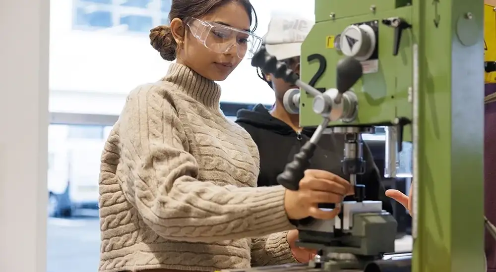 A student using a metal working machine