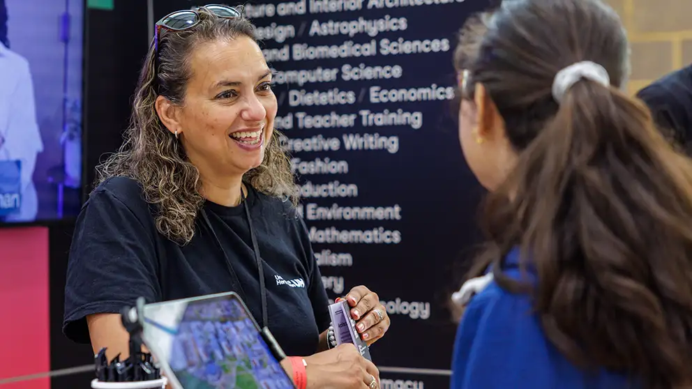 A member of staff talking to an applicant at an open day