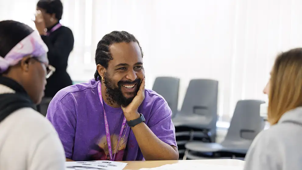 Student sitting round a table smiling
