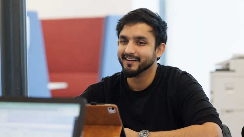 Student smiling in front of an iPad