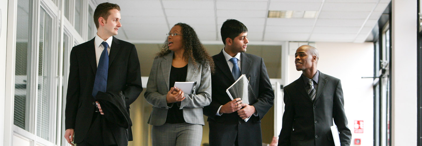 Group of male and female students walking down corridor