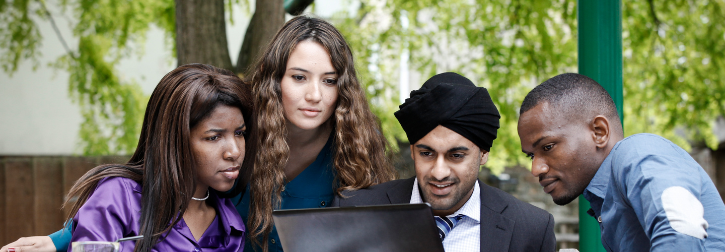 A group of students looking at work on a laptop