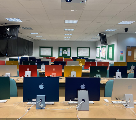 Image of a number of apple mac computers on desks
