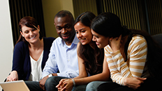Four students looking at a laptop