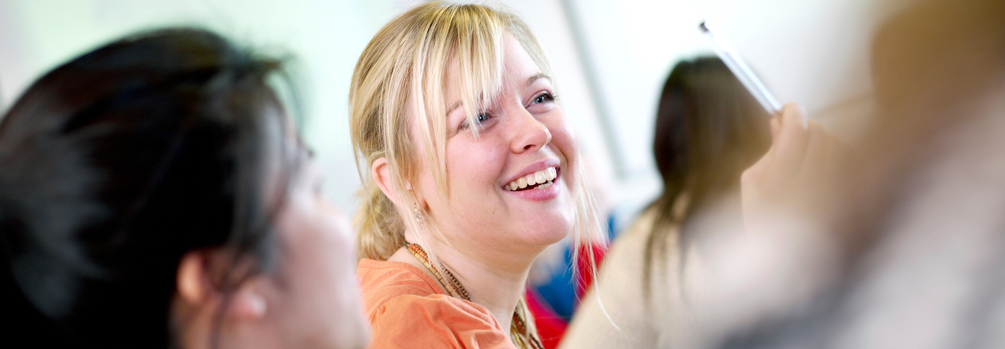 Blonde female student laughing in classroom