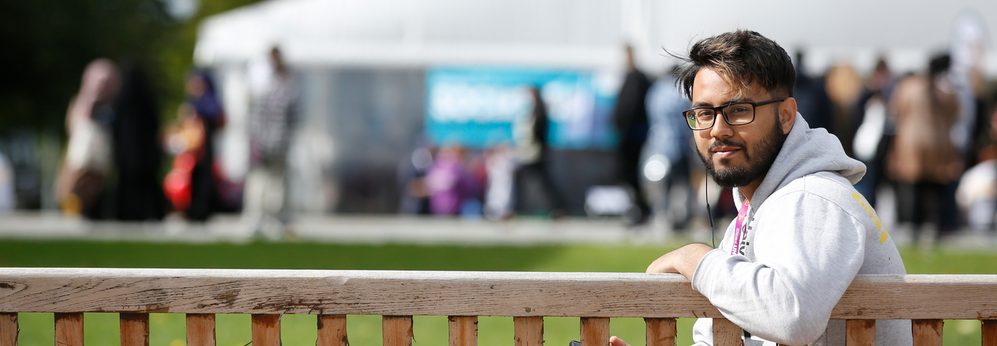 BAME student sitting on bench watching event