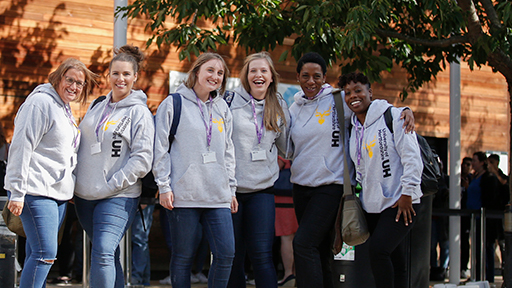 A group of students smile as they wear their Herts hoodie