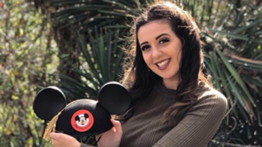 A student holds a Disney cap