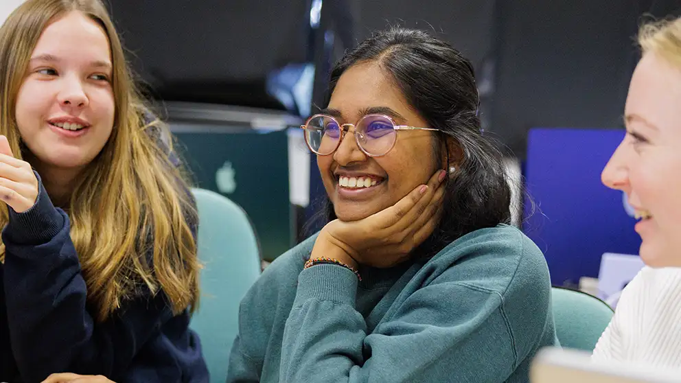 A student smiling surrounded by peers