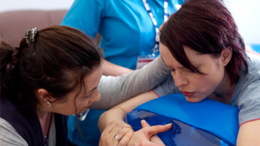 Midwifery student helping patient