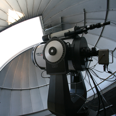 a telescope looking out from an observatory