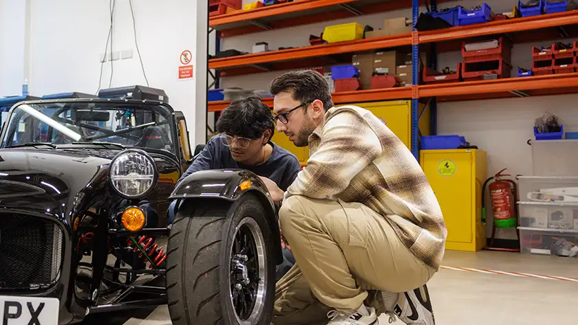 A student and lecturer working on a model car