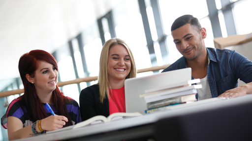 three students watching a screen