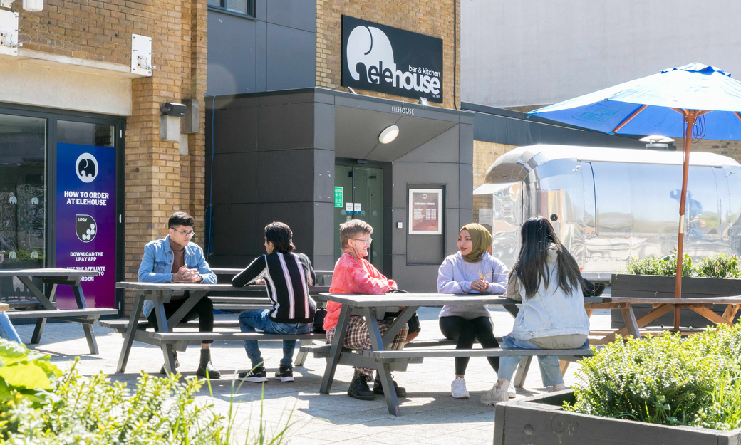 Students eating and drinking outside the Elehouse on College Lane Campus