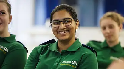 A student wearing paramedic uniform smiling
