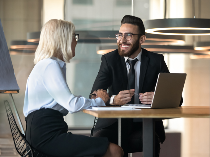 Man and woman talking over laptop