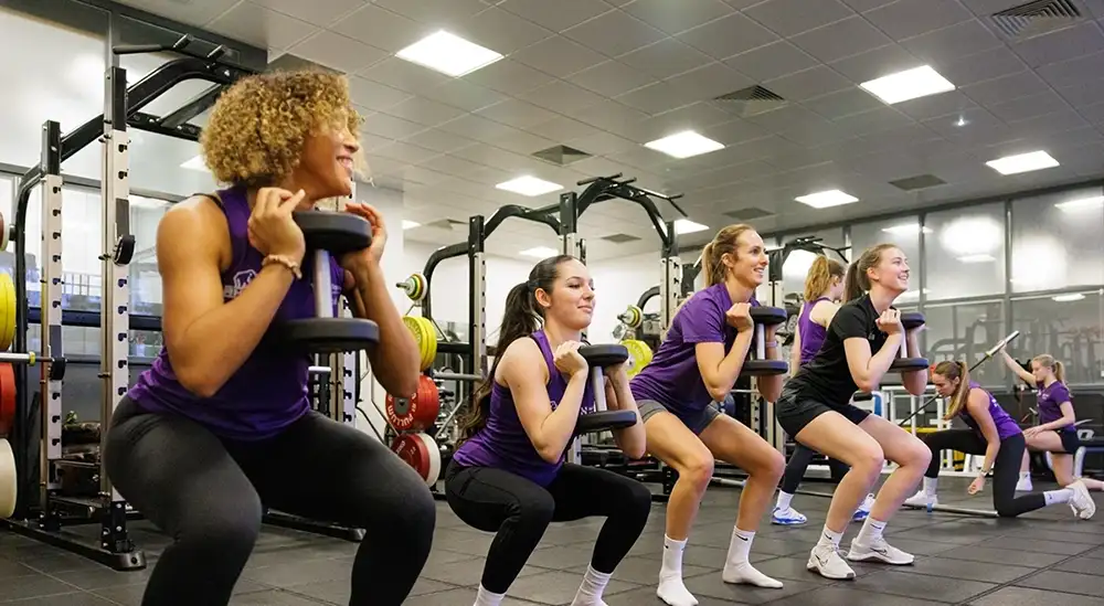 People doing weighted squats 