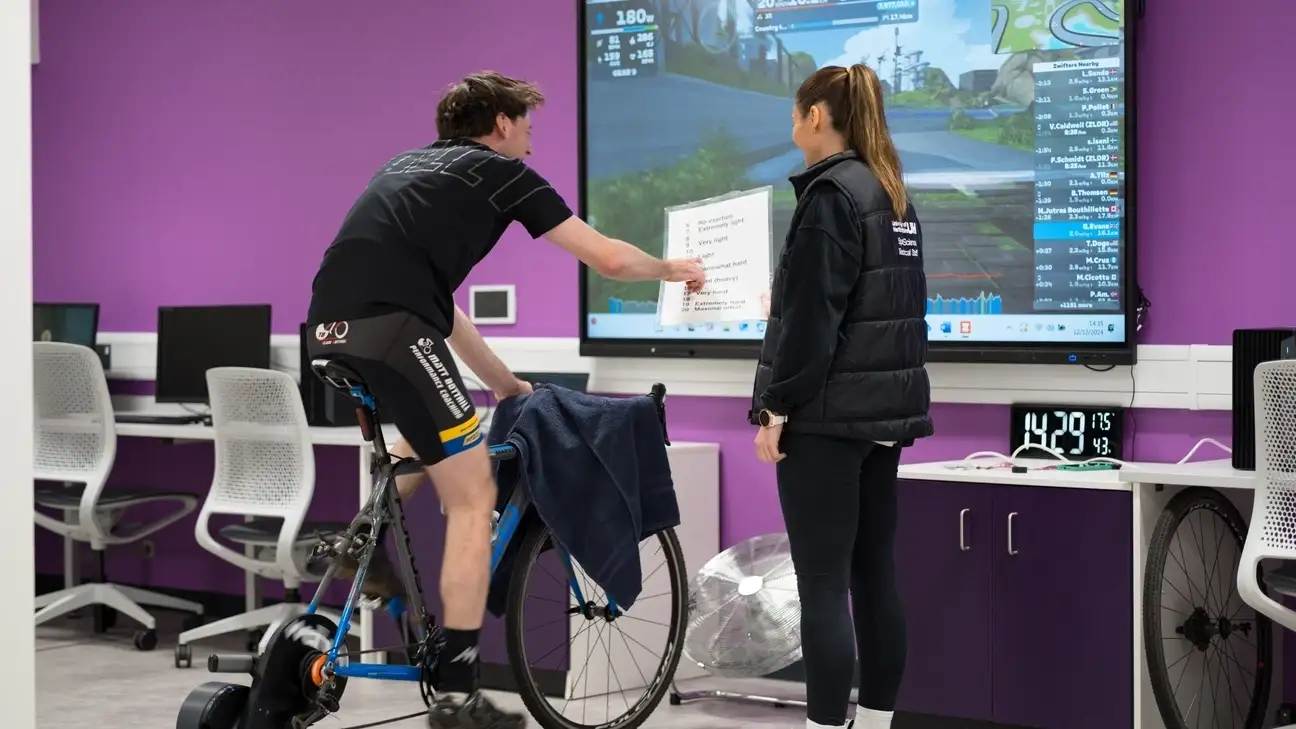 A student testing a person on bike in front of a screen