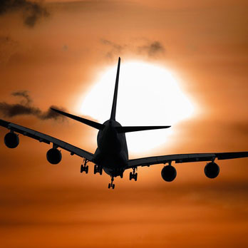 Plane flying into sunset