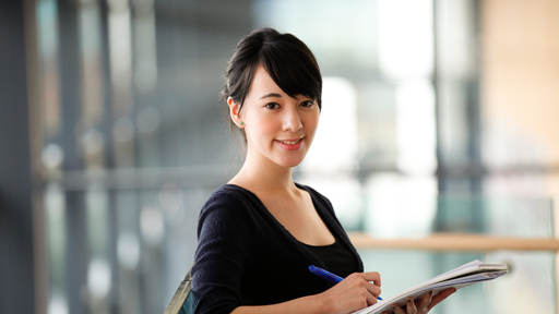 Female mature student holding pen and paper