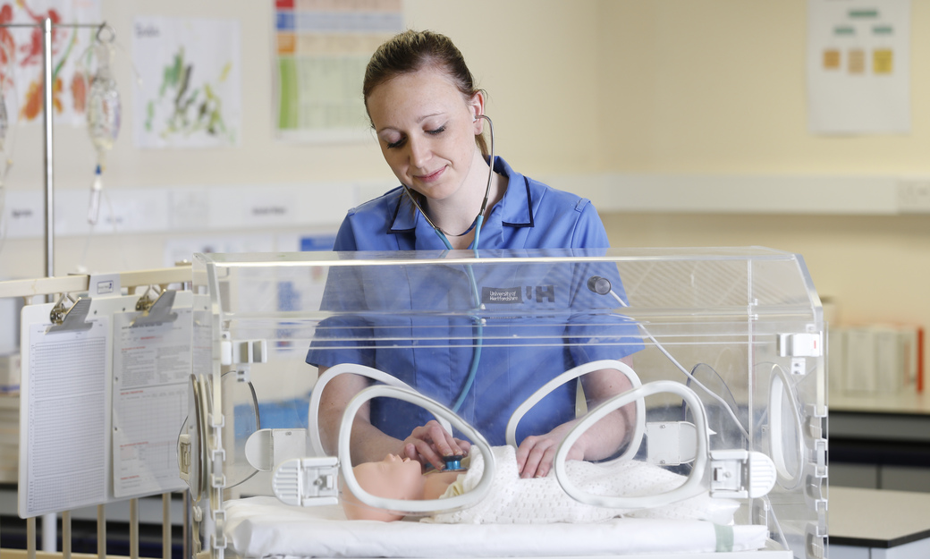 a child nurse tending to a baby mannequin 