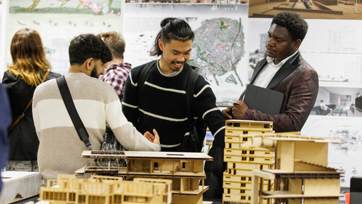 Sustainable planning students standing beside building structure model