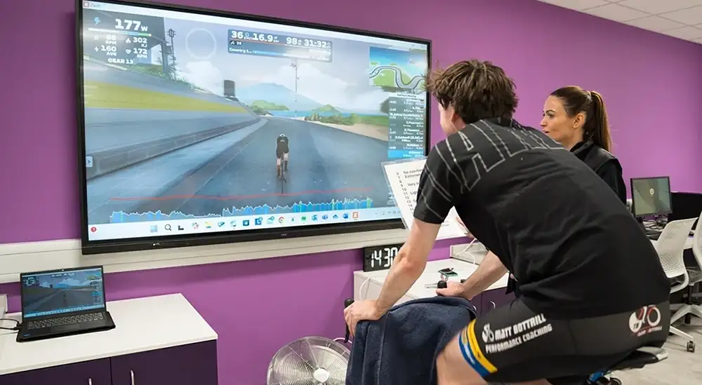A student testing a person on bike in front of a screen