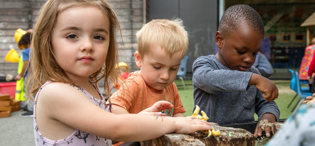 Three children playing outdoors