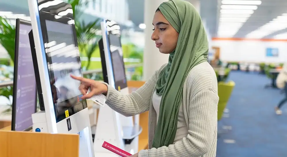 A student using a touch screen monitor to find information