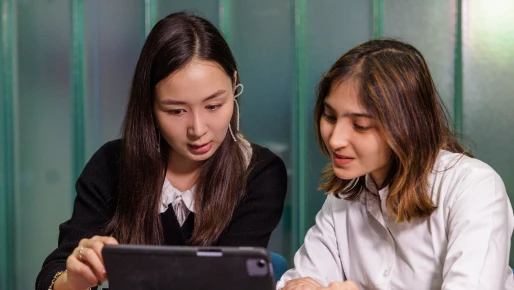Two female students talking looking at a laptop