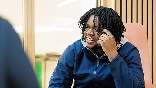 Student sitting on their own smiling